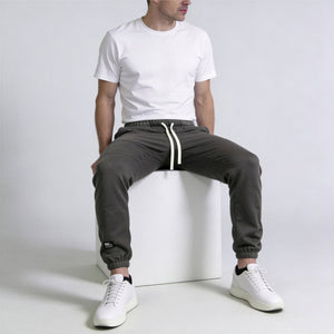 Apex Fleece Jogger model donker-grijs front zittend op een kubus