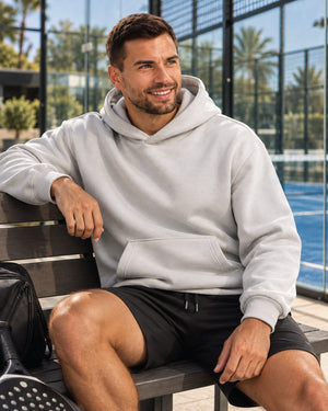 Loose-Fit-Court-Hoodie-model-licht-grijs-zittend-op-een-bankje